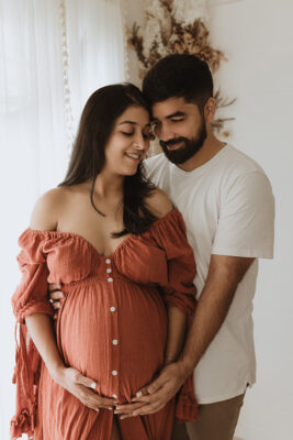 Couple mum and dad new parents holding belly third trimester