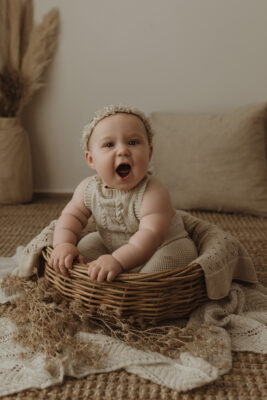 Smiling baby sitting in basket in Melbourne
